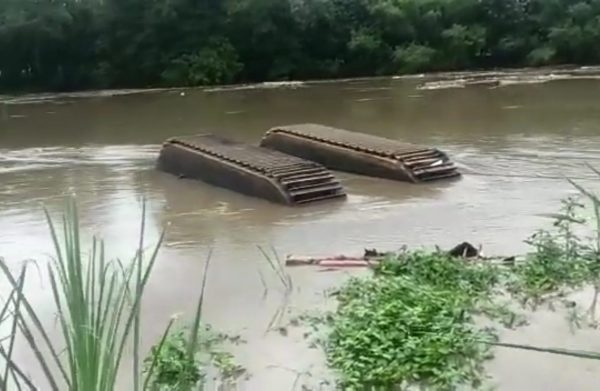 Alat berat jenis ekskavator tampak haanyut di sungai bengawan solo dengan kondisi terbalik.